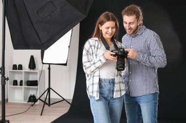 Profesyonel fotoğrafçı stüdyoda model resimleri gösteren