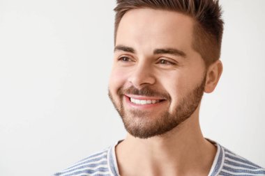 Yakışıklı genç adam beyaz arka plan üzerinde gülümseyen