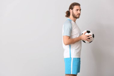 Gri arka planda erkek futbolcu
