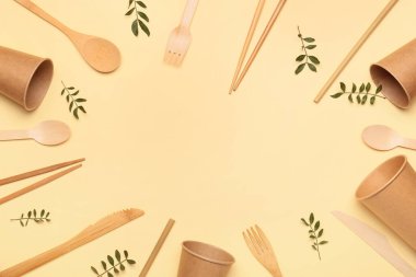 Eko bardaklardan ve renk arkaplanındaki çatal bıçaklardan oluşan çerçeve