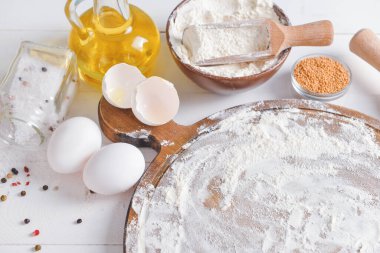 Beyaz ahşap arka planda lezzetli pizza için malzemeler