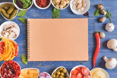 Tahta arka planda lezzetli pizza ve defter malzemeleri