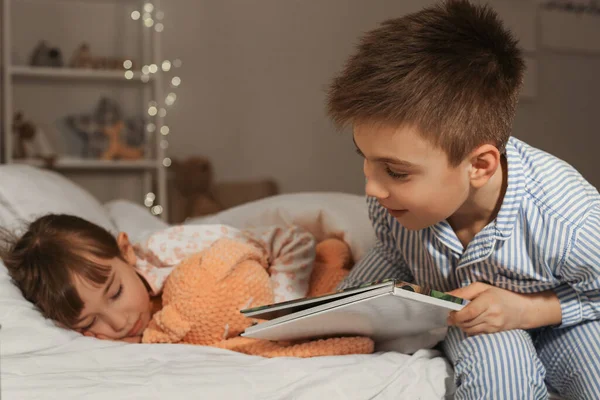 Little Girl Falling Asleep While Her Brother Reading Bedtime Story — Stock Photo, Image