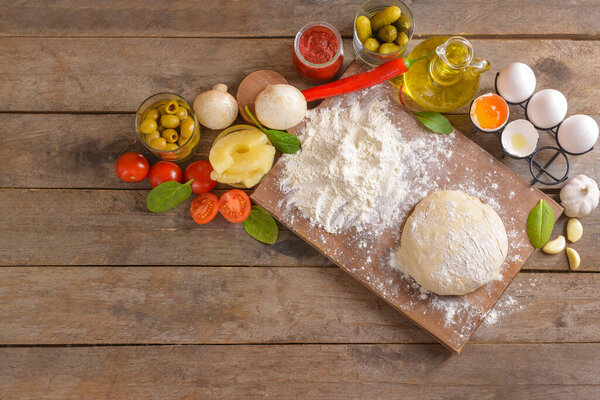 Ingredients for tasty pizza on wooden background