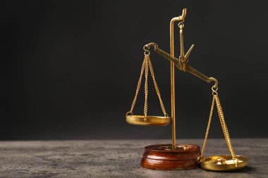 Masadaki adalet terazileri karanlık arka planda.