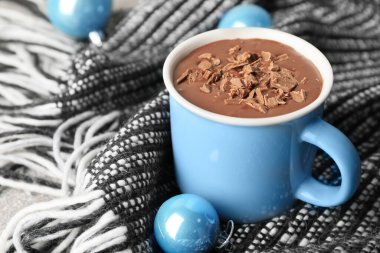 Masada bir fincan sıcak çikolata ve Noel süsü.