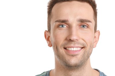 Beyaz arka planda sağlıklı dişleri olan yakışıklı bir genç.
