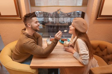 Kafede romantik bir randevuda olan mutlu genç çift