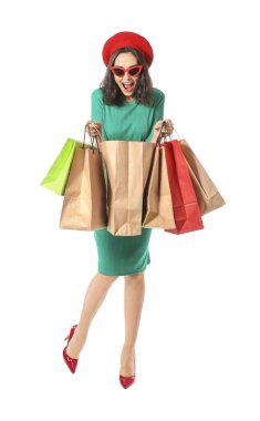 Beyaz arka planda alışveriş torbaları olan güzel genç bir kadın.