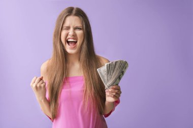 Renkli arka planda parası olan güzel, mutlu kadın.