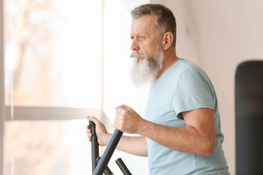 Sportif yaşlı adam spor salonunda çalışıyor.