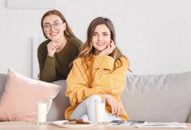 Evde kalın kazaklı genç kadınlar var.