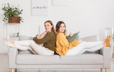 Evde kalın kazaklı genç kadınlar var.