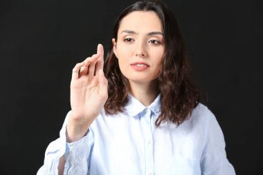 İş kadını koyu arkaplanda sanal ekran kullanıyor