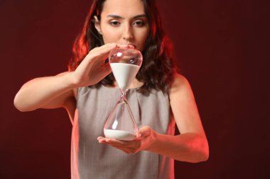 Renkli arka planda kum saati olan kadın. Zaman yönetimi kavramı