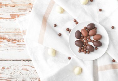 Tabakta çikolatalı yumurta ve ahşap masa şekeri var.