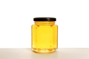 Beyaz arka planda tatlı bal kavanozu