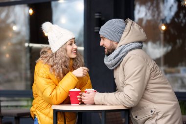 Açık kafede sıcak çikolata içen mutlu genç çift