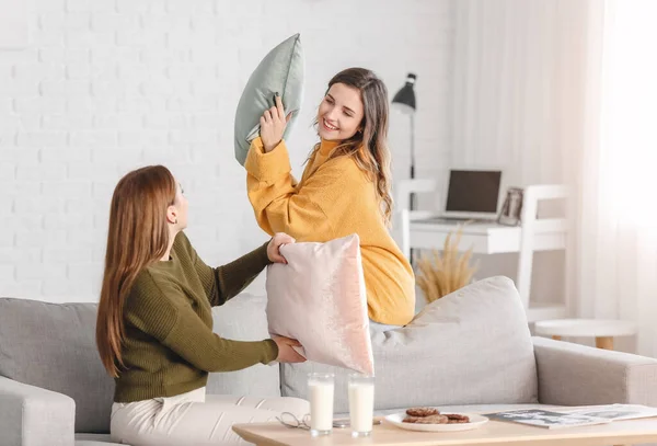 Young Women Warm Sweaters Fighting Pillows Home — Stock Photo, Image