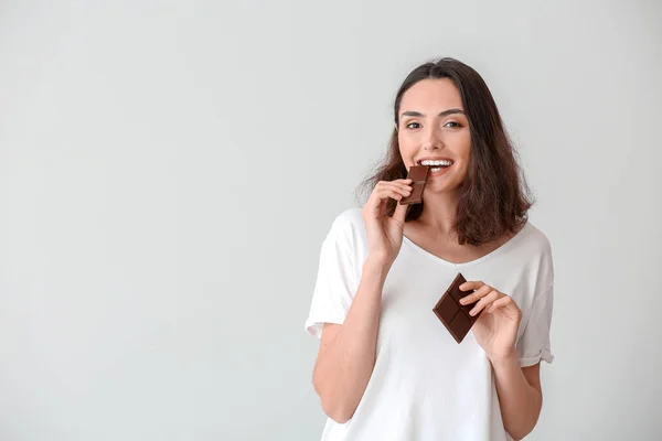 Όμορφη Νεαρή Γυναίκα Τρώει Νόστιμη Σοκολάτα Λευκό Φόντο — Φωτογραφία Αρχείου