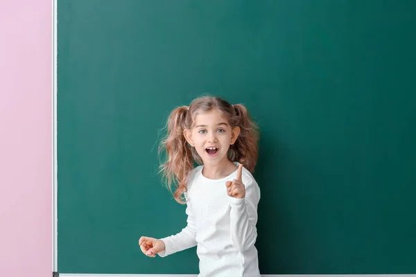 Cute Little Schoolgirl Raised Index Finger Blackboard Classroom — Stock Photo, Image