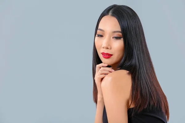 Gri Arkaplanda Güzel Saçları Olan Genç Asyalı Kadın — Stok fotoğraf