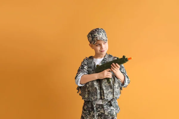 かわいいです兵士とともにおもちゃ銃上の色の背景 — ストック写真