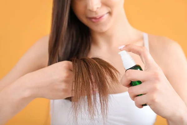 Jovem Mulher Usando Cosméticos Para Cabelos Fundo Cor Close — Fotografia de Stock