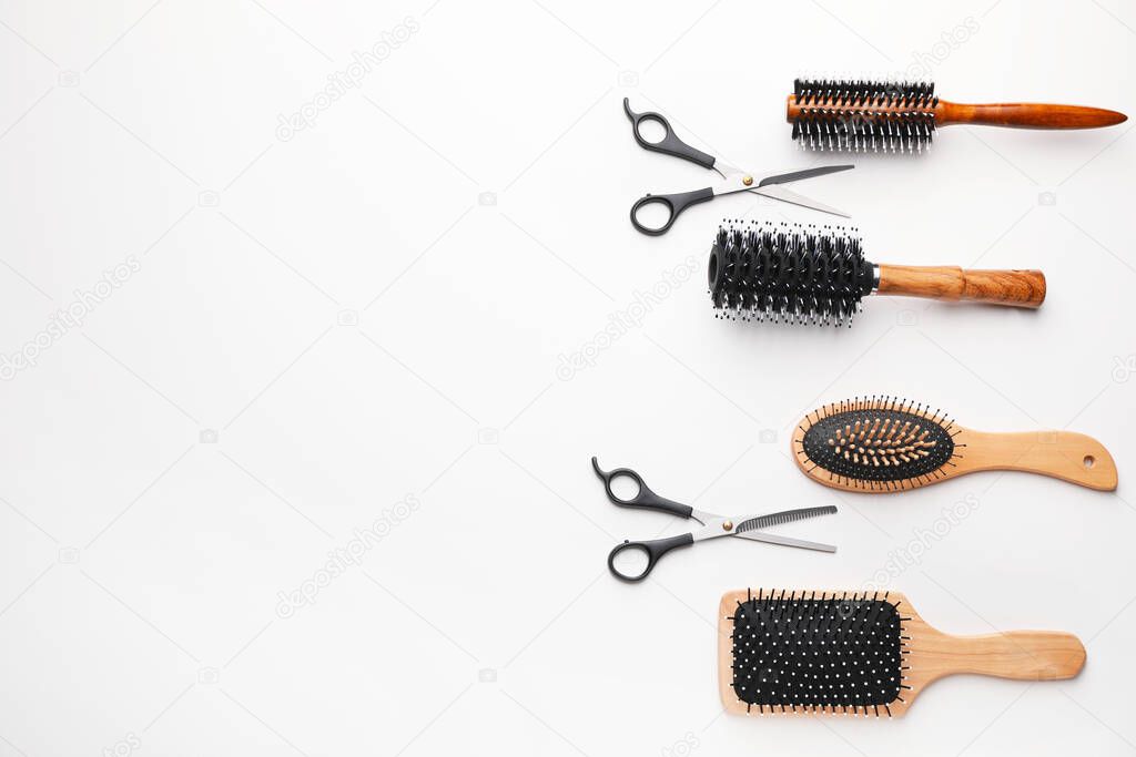 Hair brushes with scissors on white background