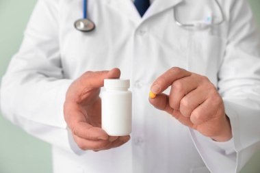 Renkli arka plan hapları olan kıdemli doktor, yakın plan.