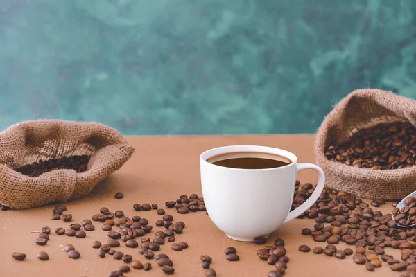 テーブルの上に熱いコーヒーと豆のカップ — ストック写真