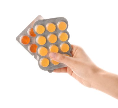 Beyaz arka planda hapları olan bir kadın.