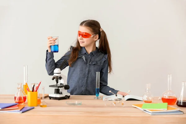 Schattig Klein Meisje Studeren Chemie Aan Tafel Tegen Grijze Achtergrond — Stockfoto