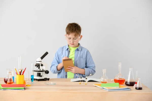 かわいい男の子勉強化学でテーブルで灰色の背景 — ストック写真
