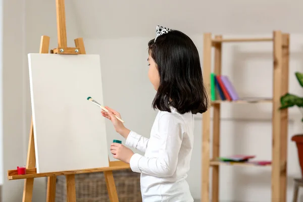 Cute little artist painting at home