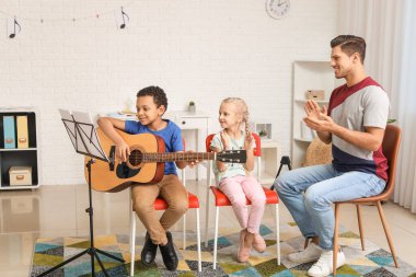Teacher giving music lessons at school