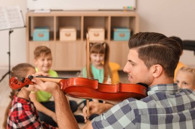 Teacher giving music lessons at school