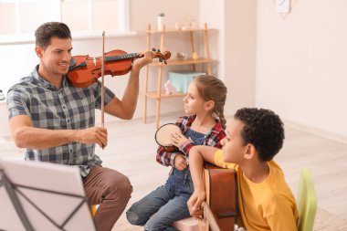 Teacher giving music lessons at school