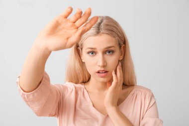 Açık arkaplanda güzel makyajlı genç bir kadın.