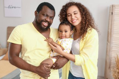 Mutlu Afro-Amerikan ebeveynler ve evde şirin bir bebek
