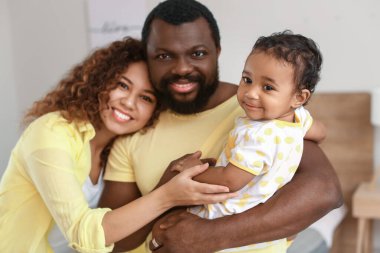 Mutlu Afro-Amerikan ebeveynler ve evde şirin bir bebek