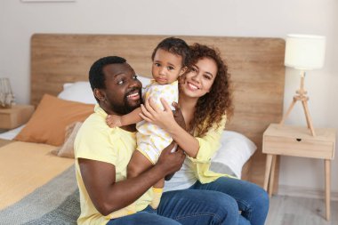 Mutlu Afro-Amerikan ebeveynler ve evde şirin bir bebek