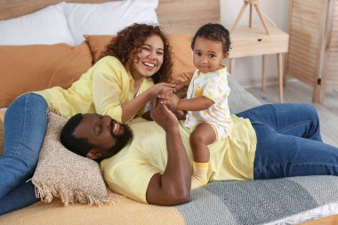 Mutlu Afro-Amerikan ebeveynler ve evde şirin bir bebek