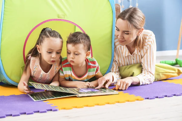 Νταντά Και Χαριτωμένα Μικρά Παιδιά Ανάγνωση Του Βιβλίου Στο Σπίτι — Φωτογραφία Αρχείου