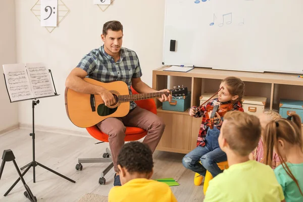 Teacher giving music lessons at school