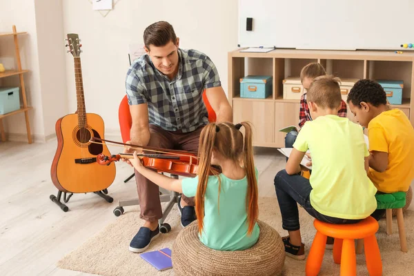 Teacher giving music lessons at school