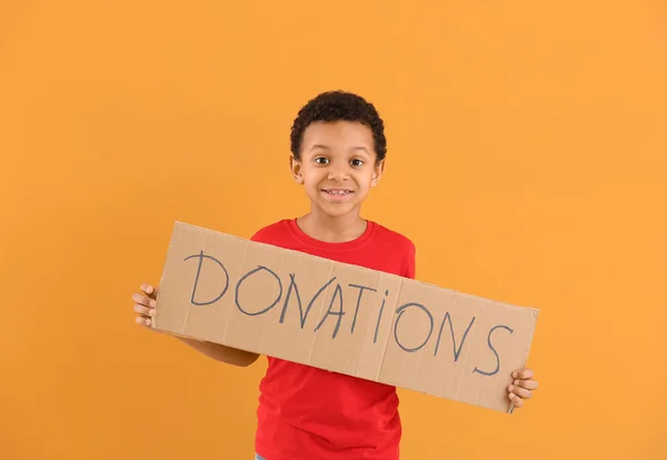 Mały Afroamerykanin Trzymający Karton Tekstami Donacje Tle Koloru — Zdjęcie stockowe