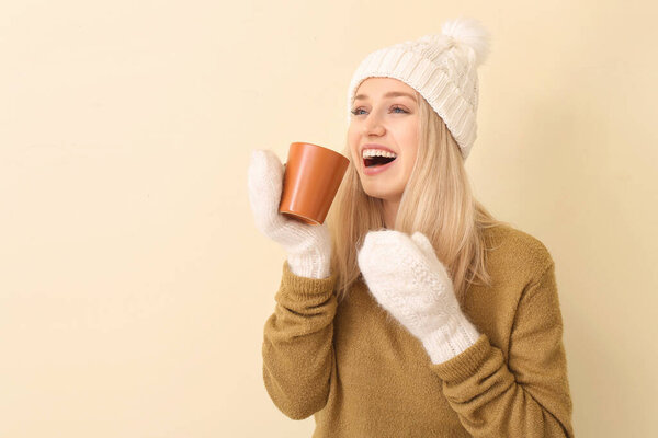 Beautiful young woman with tea on color background