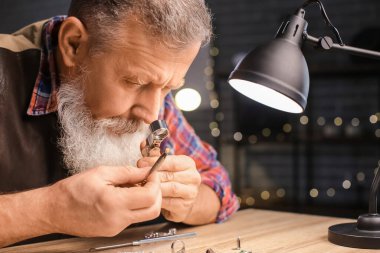 Mücevher atölyesinde mücevher inceliyor.