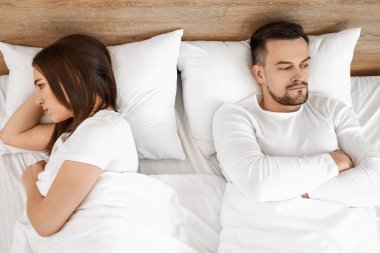 Yatak odasında tartışan genç bir çift.